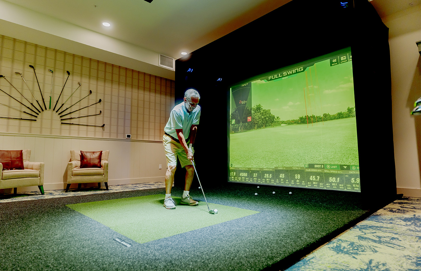 A person playing a golf simulator.