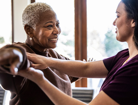 Resident doing physical therapy with an associate.