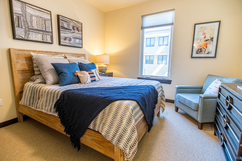 The Watermark at Cherry Hills apartment with two paintings above bed.