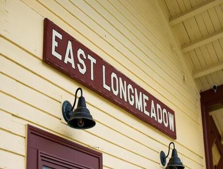 Side of yellow building that has a sign reading East Longmeadow.