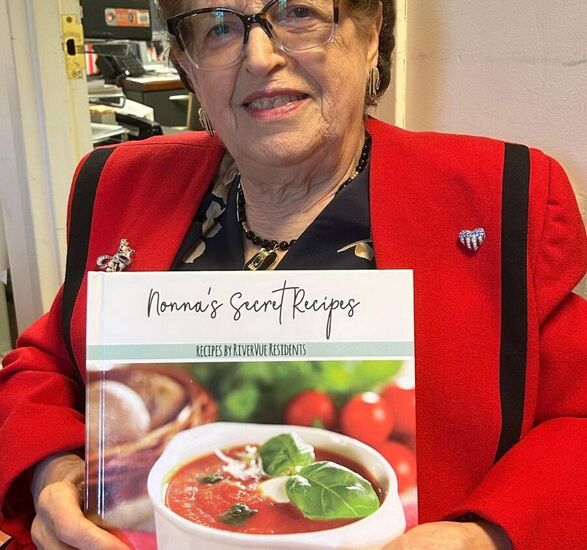 Helen, a resident, is holding a cookbook.
