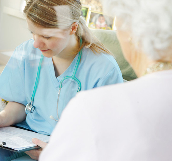 A medical person writing on a clipboard.