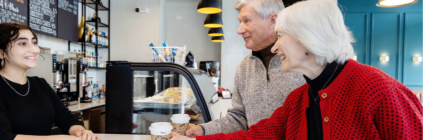 People at the counter buying coffee. People at the counter buying coffee.