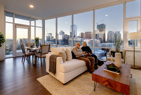 A fully furnished apartment with large windows at The Watermark at Bellevue senior living community.