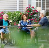 Friends at a table in a courtyard.