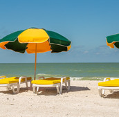 Three beach umbrellas in the sand.
