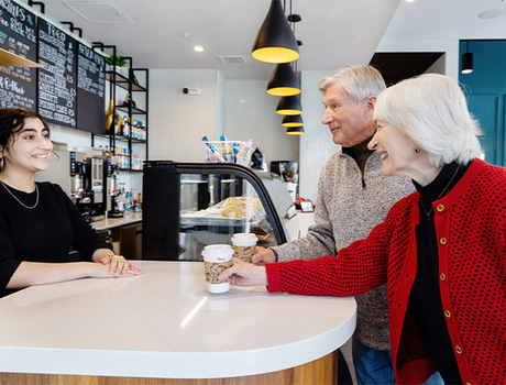People getting coffee from a cafe counter.