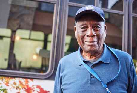 Resident standing outside community bus.