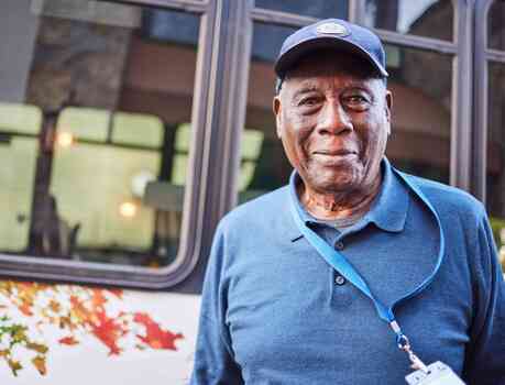 Resident standing outside community bus.