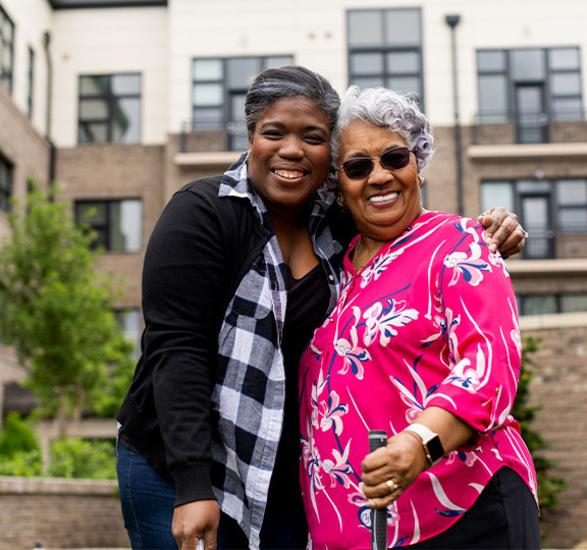 Two people outside smiling.