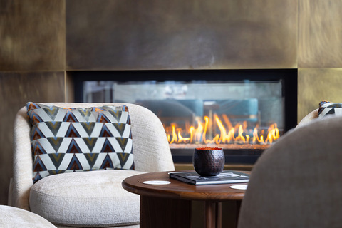 A chair near a fireplace.