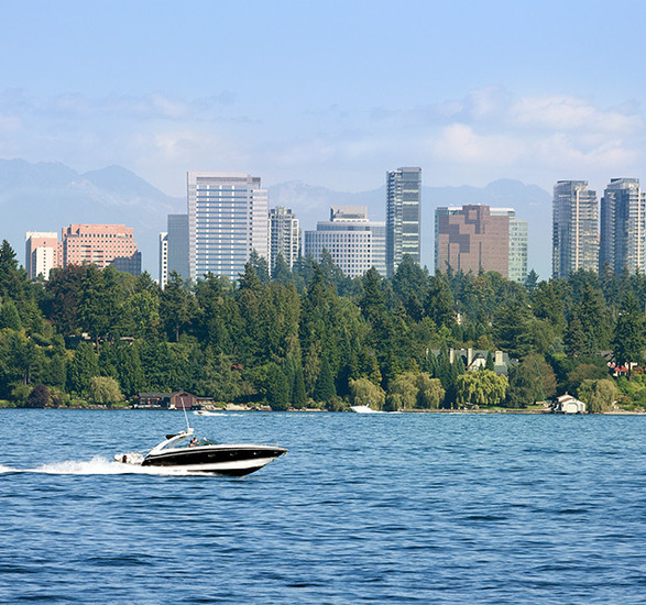 A boat on a lake with a city behind it.