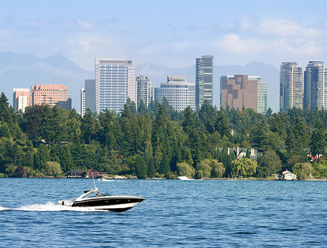 A boat on a lake with a city behind it.