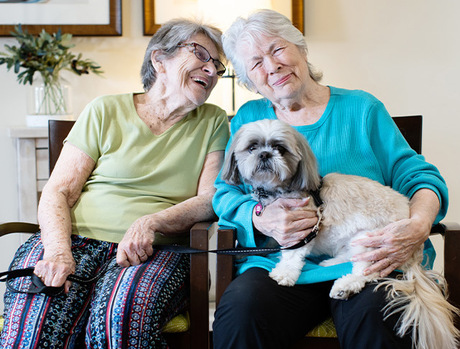 Two people with a dog on the couch.