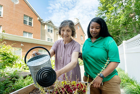 A person watering plants at Rockland Place Senior Living Community in Wilmington, DE