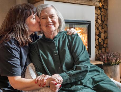 Daughter kissing mother on cheek.