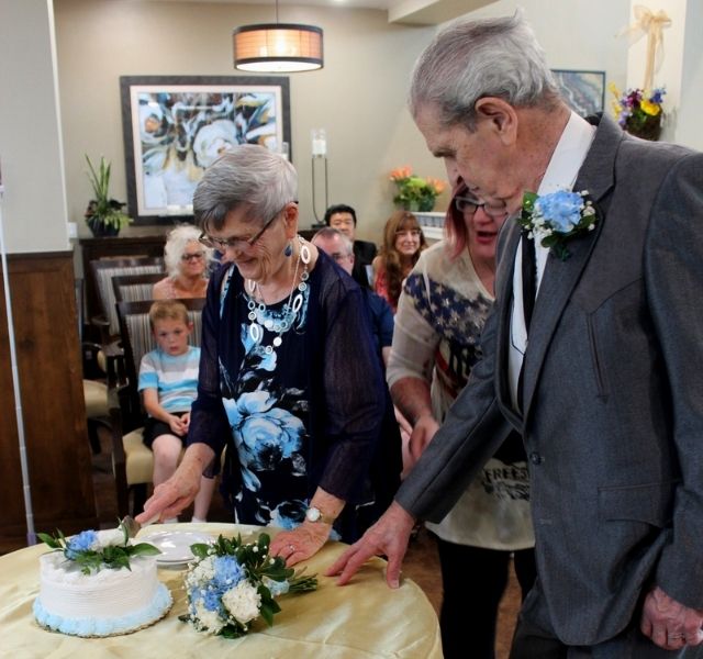 Couple cutting wedding cake.