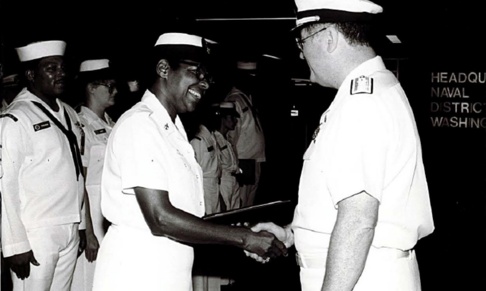 Two Navy individuals shaking hands.
