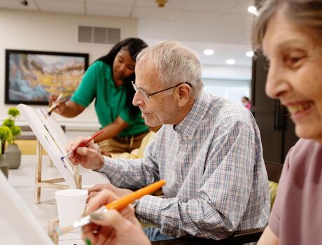 3 residents painting on canvas
