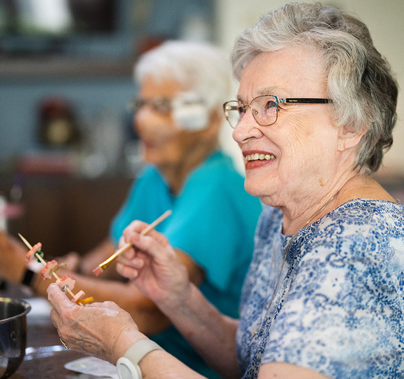 Residents enjoying an art class with canvases and paint brushes.