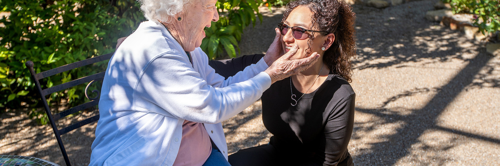 A resident is with a caregiver outside. A resident is with a caregiver outside.