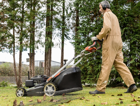 A worker mows the lawn outdoors, representing the time and effort that home maintenance can require.