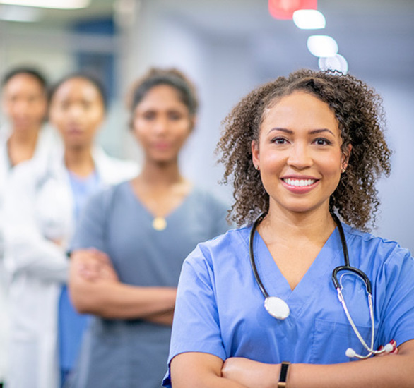 Four nurses smiling.