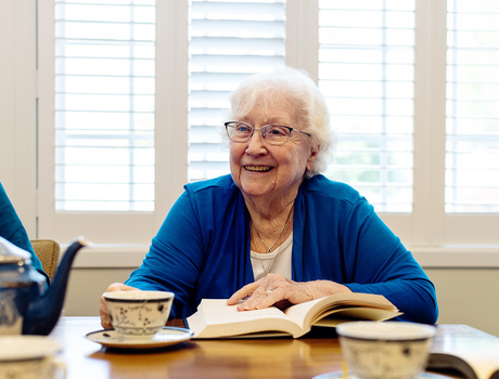 A person sitting at a table with a book.