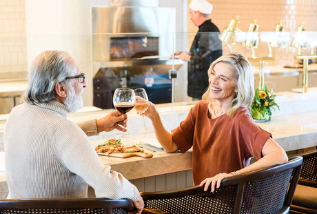 Two residents are enjoying glasses of wine at the bar.