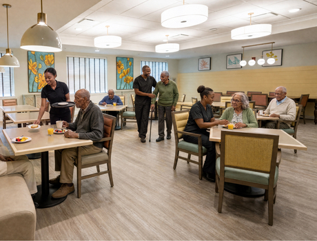 Memory Care dining room at the The Sky Bridge at Town Center. Residents eating breakfast while caregivers and wait staff help.