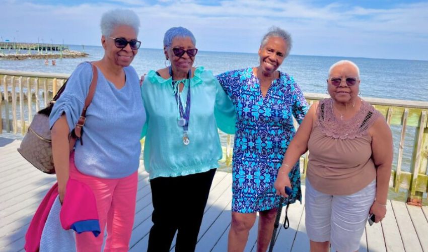 A group of ladies in front of a beach.