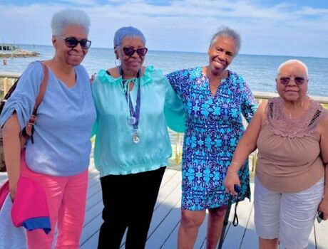 A group of ladies in front of a beach.