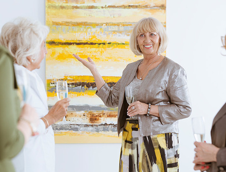 People viewing art and drinking wine.
