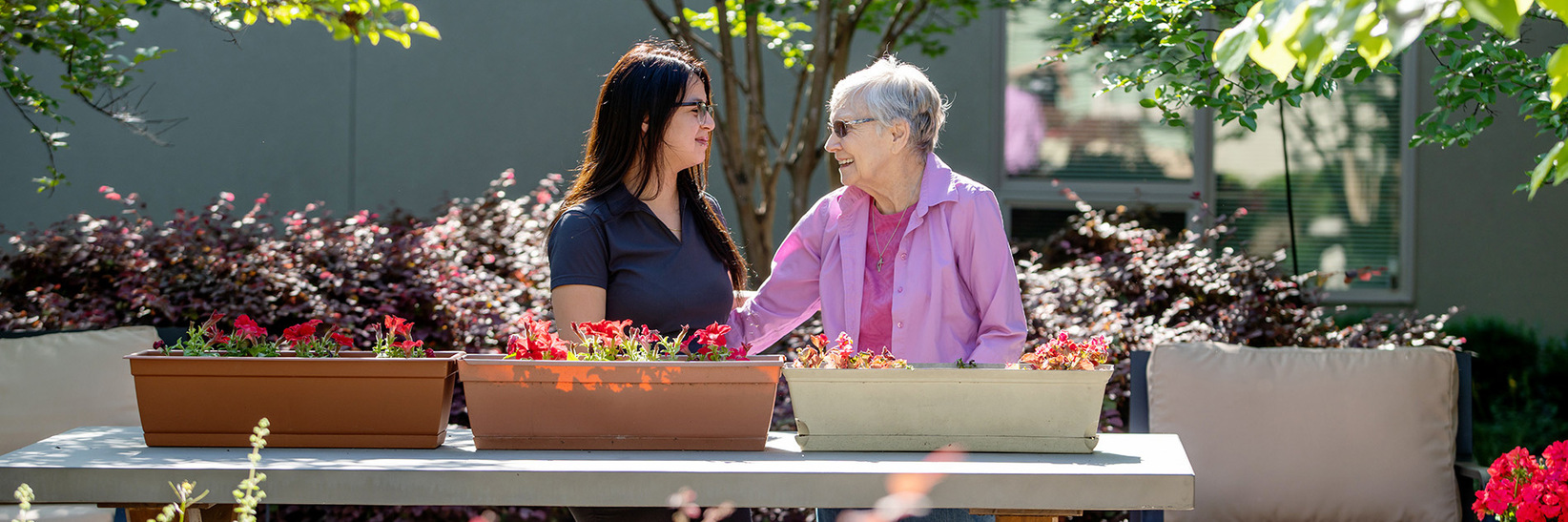 A caregiver and resident in the garden.