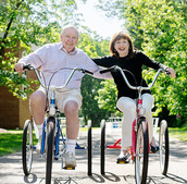 Two people riding bikes together.