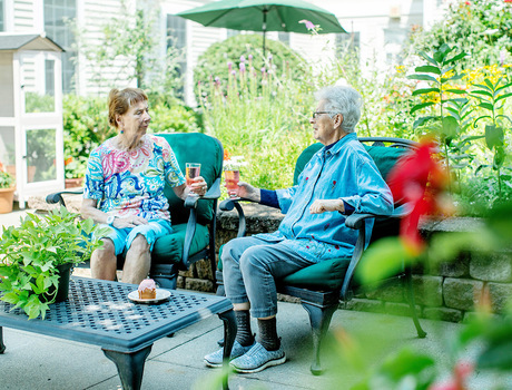 Two residents are in the courtyard at East Village Place senior living community in East Long Meadow.