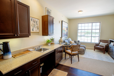 A furnished kitchen looking into the living room.