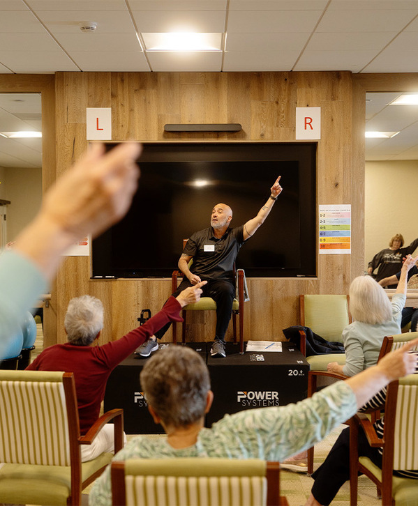 Accordion image People in a seated fitness class.
