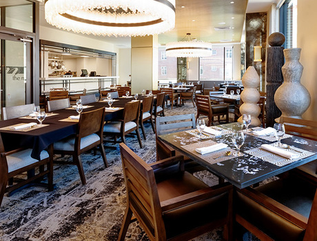 A dining room with tables set for dinner.