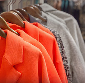 Colorful coats on hangers are hung up.