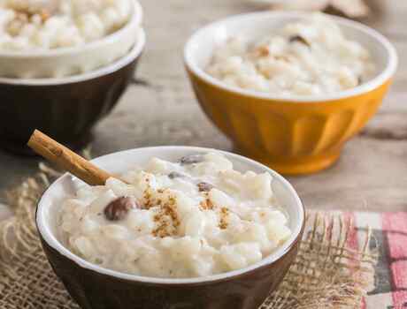 Three bowls of rice pudding with cinnamon on top.
