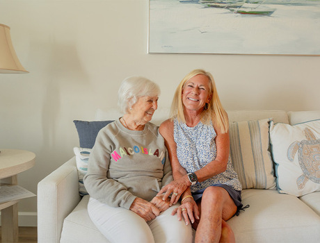 Two people laughing on a couch.