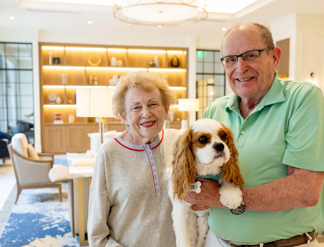 Two people holding their dog.
