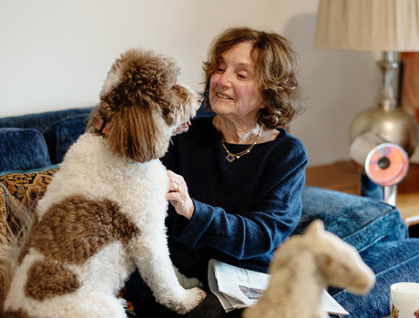 A person on the couch with their dog.