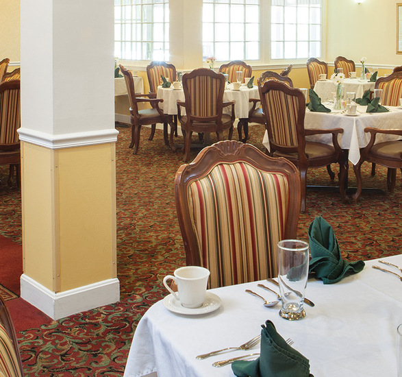 A dining room with tables and chairs.