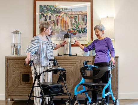Two people with walkers getting coffee.