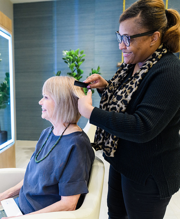 A resident is having their hair styled at a salon.