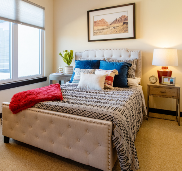 Bed next to nightstand and window.
