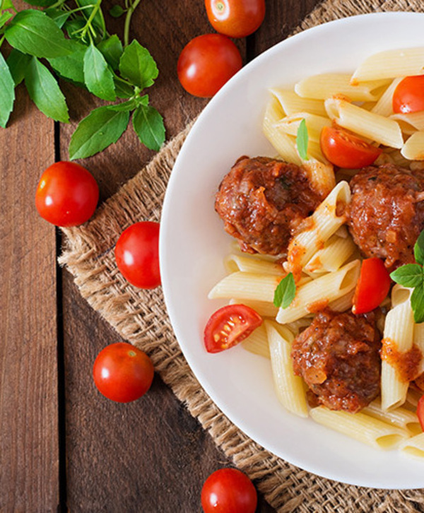 A plate of penne pasta with meatballs. A plate of penne pasta with meatballs.