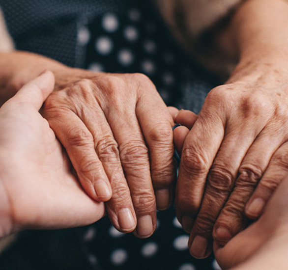 Hands holding another person's hands.